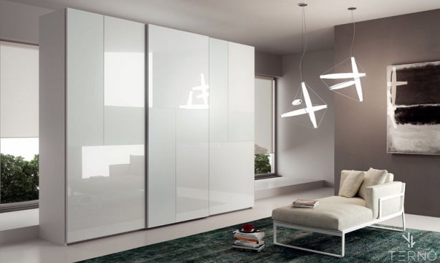 Armoire moderne dans la chambre avec façades en panneaux brillants et mats